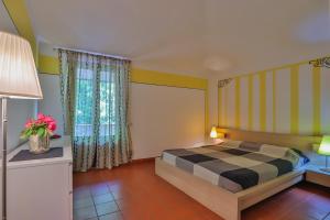 1 dormitorio con cama, lámpara y ventana en Residence Il Castagno, en Pistoia