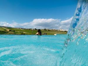 a woman is standing in a pool of water at Agriturismo La Casa di Bacco in Agrigento