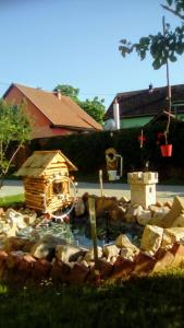 ein kleiner Teich mit einem Vogelhaus im Hof in der Unterkunft Apartman Peric in Ðakovo