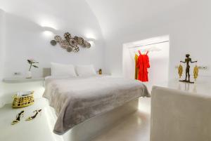 biała sypialnia z łóżkiem i stołem w obiekcie Antrum Cave Villa w Imerovíglion +15 zdjęć