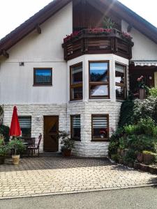 een huis met een balkon en een rode paraplu bij Mosel-Ferienwohnung Berhard in Bruttig-Fankel