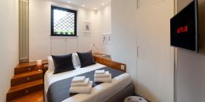 a bedroom with a bed with pillows and a tv at Suite Augustus - free parking in Genoa