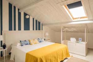 1 dormitorio con 1 cama con manta amarilla en Civico 64 Bed & Breakfast in mansarda, en Palmi