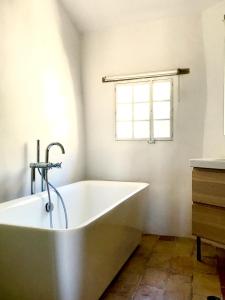 La salle de bains est pourvue d'une baignoire et d'une fenêtre. dans l'établissement la bonbonniere - Townhouse Saint-Saturnin-lès-Apt, à Saint-Saturnin-lès-Apt