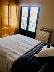 - une chambre avec un grand lit et une fenêtre dans l'établissement Vergarillas 2, à Ávila