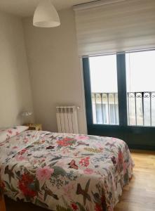 a bedroom with a bed with a floral comforter on it at Vergarillas 2 in Ávila
