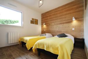 2 camas en una habitación con paredes de madera en Le Balcon des Lumières, en Gérardmer