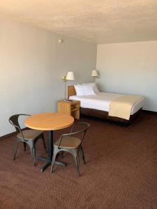 a hotel room with a bed and a table and chairs at EZ 8 Motel Airporter in Phoenix +19 photos