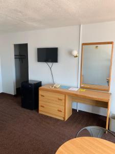 a room with a desk with a mirror and a dresser at EZ 8 Motel Airporter in Phoenix
