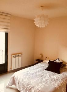 a bedroom with a bed and a chandelier at Vergarillas 1 in Ávila +3 photos