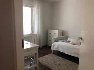une chambre avec un lit, une commode et une fenêtre dans l'établissement Villa Kalliorinne, à Jyväskylä