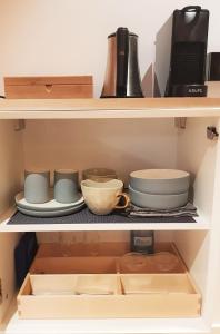 a kitchen with a shelf full of pots and pans at 23 SouS in Amsterdam