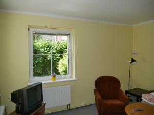 een kamer met een televisie, een stoel en een raam bij Apartament w centrum Gdyni in Gdynia