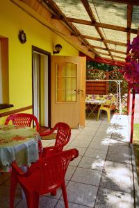 a patio with a table and chairs and a yellow house at Domki letniskowe U GOSI in Trzęsacz