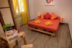 Schlafzimmer mit einem Bett mit roter Bettwäsche und orangefarbenen Kissen in der Unterkunft B&B L'Arca Di Noè in La Spezia
