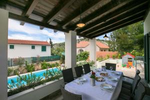 a dining table on a patio next to a pool at Villa Marina in Ražanj
