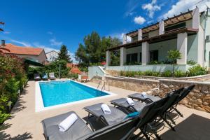 a villa with a swimming pool and patio furniture at Villa Marina in Ražanj