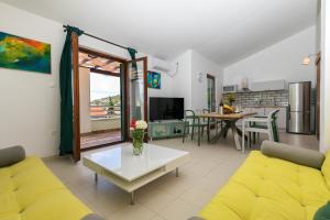 a living room with a yellow couch and a table at Villa Marina in Ražanj
