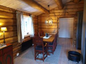 a dining room with a wooden table and chairs at Koselig familiehytte sentralt på Skeikampen til leie in Svingvoll +16 photos