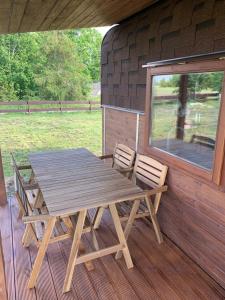 a wooden picnic table and chairs on a porch at Labrags Saulrieti in Jūrkalne