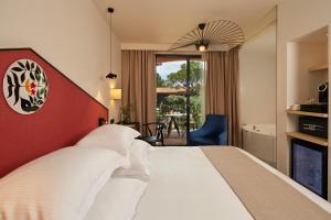 a hotel room with a bed and a tv at Villa Duflot Hôtel & Spa Perpignan in Perpignan