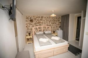 a bed in a room with a stone wall at Rooms Epidaurus in Dubrovnik