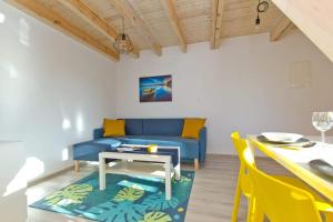 a living room with a blue couch and a table at Domki Reston in Jastrzębia Góra