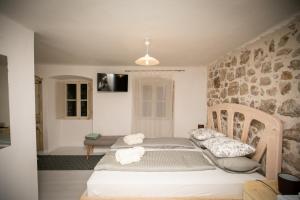 a bedroom with two beds and a stone wall at Rooms Epidaurus in Dubrovnik