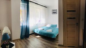 niewielka sypialnia z łóżkiem i oknem w obiekcie Pokoje i Apartamenty 200 m do plaży w Karwii