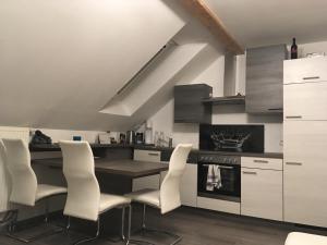 uma cozinha com cadeiras brancas, uma mesa e um forno em Appartement GL24 em Sankt Margarethen bei Knittelfeld