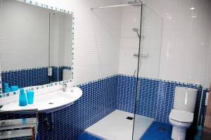 a blue tiled bathroom with a sink and a shower at Apartamentos Costa Costa in Suances +29 photos