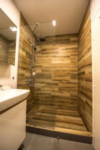y baño con ducha y paredes de madera. en La Vecchia Signora APARTMENT, en Skopje