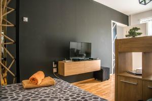 a bedroom with a bed and a tv on a wall at La Vecchia Signora APARTMENT in Skopje