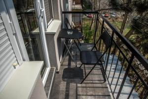 een balkon met 2 stoelen en een tafel bij La Vecchia Signora APARTMENT in Skopje