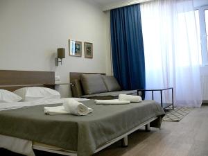 ein Hotelzimmer mit zwei Betten und einer Couch in der Unterkunft Marjanishvili Studios in Tbilisi City