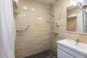 ein Badezimmer mit Dusche, Waschbecken und Spiegel in der Unterkunft Marjanishvili Studios in Tbilisi City + 16 Fotos