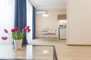 ein Wohnzimmer mit einem Tisch und einer Blumenvase in der Unterkunft Marjanishvili Studios in Tbilisi City