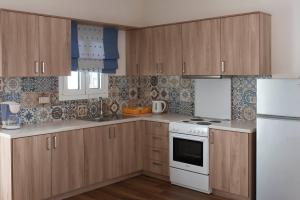 a kitchen with wooden cabinets and a white stove top oven at La Sapienza in Methoni