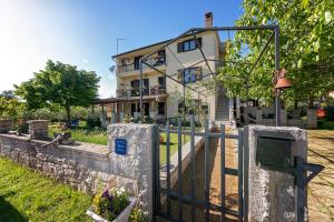 a house with a fence in front of it at Blue Apartment in Vrsar