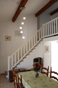 een eetkamer met een tafel en een witte trap bij La Garonnette - 150m de la plage in Sainte-Maxime