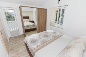 a small bedroom with a bed and a mirror at Apartment Kalle in Kotor