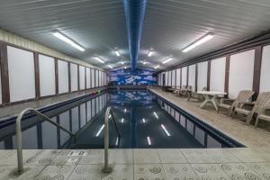 a swimming pool with chairs and a table in a building at Chena Hot Springs Resort in Chena Hot Springs