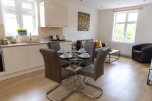 cocina y sala de estar con mesa y sillas en London Northwick Park Serviced Apartments by Riis Property, en Harrow