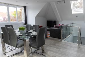uma sala de jantar com uma mesa e cadeiras e um sofá em London Northwick Park Serviced Apartments by Riis Property em Harrow