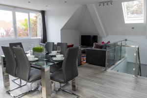 een eetkamer met een tafel en stoelen en een bank bij London Northwick Park Serviced Apartments by Riis Property in Harrow