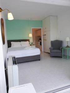- une chambre avec un lit, un canapé et une chaise dans l'établissement Sea Satin Sounio, à Cap Sounion