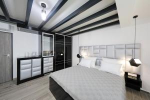 1 dormitorio con 1 cama grande con almohadas blancas en Boutique Residence Cosmopolis, en Bibinje