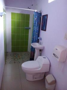 a bathroom with a toilet and a sink at Cabinas El Muellecito in Tortuguero