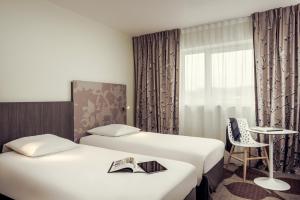Rúm í herbergi á Mercure Compiègne Sud