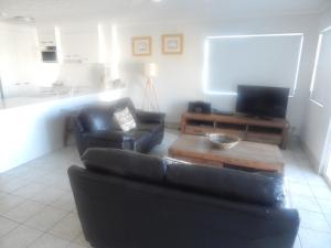 a living room filled with furniture and a tv at Tranquil Shores in Caloundra